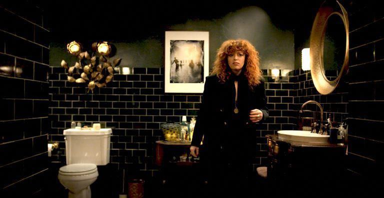 red haired woman in a pretty bathroom with dark tile